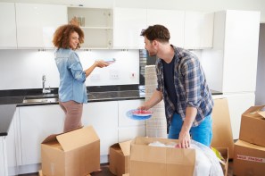 Couple Moving Into New Home And Unpacking Boxes